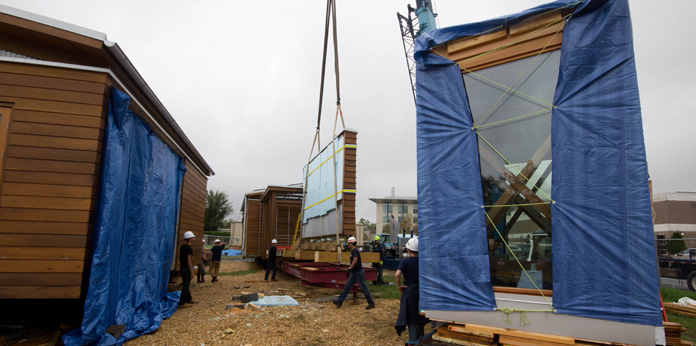Photo of the house components being loaded onto their transport carriers