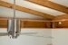 Photo of ceiling fan, cable lights, and exposed rafters