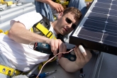 Photo of Brian Borak installing PV panels