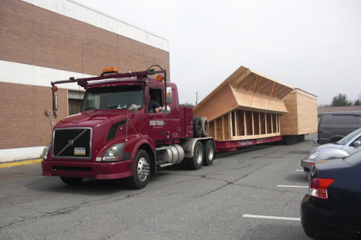 Photo of house framing arriving on a flat bed truck